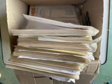 une boîte en carton remplie de papiers, posée sur une table