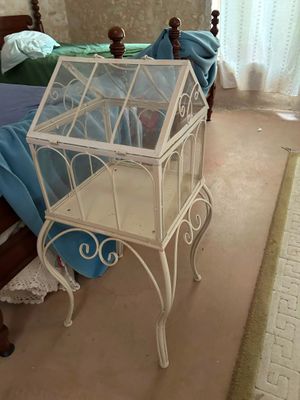 a small white bird cage sitting on top of a bed