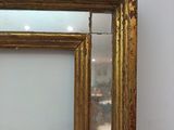 an image of a gold framed mirror on a white wall