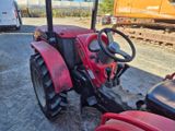 a red tractor that is sitting in the dirt