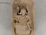 a statue of an angel holding a bird on a plaque