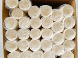 many rolls of toilet paper in a cardboard box