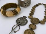 a white table topped with assorted items including a bracelet, ring, and a pair of scissors