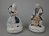 paire de figurines en porcelaine représentant un homme et une femme assis sur une chaise