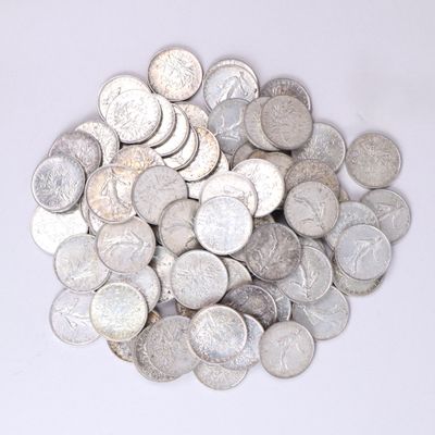 une pile de pièces d'argent posée sur une surface blanche