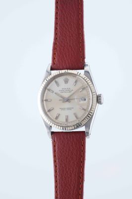 a close up of a wrist watch with a red leather strap