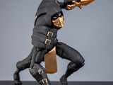 La figurine est posée sur un socle noir rehaussé de touches dorées.