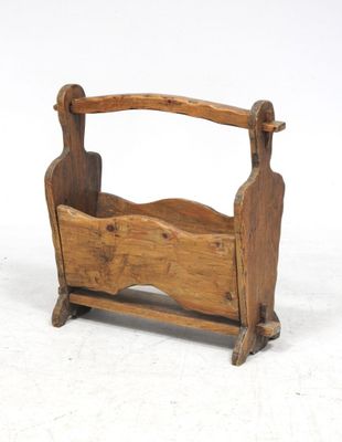 un vieux porte-revues en bois muni d'une poignée en bois, sur fond blanc