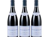 three bottles of wine sit side by side on a white surface