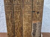 three old books are stacked on top of each other on a table