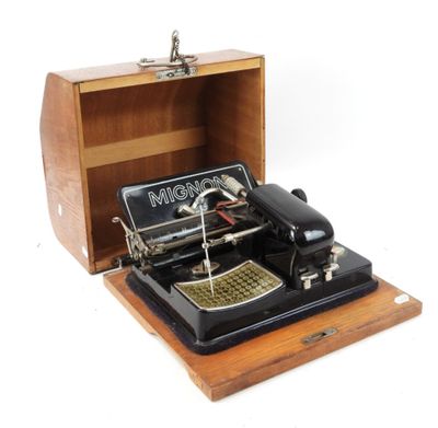 une machine à coudre à l'ancienne dans une boîte en bois posée sur une surface blanche