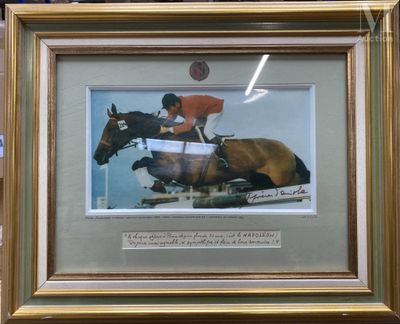 une photo d'un cheval et de son cavalier en train de franchir une haie