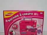 the box of a pink sewing machine is sitting on a table