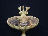 a bird that is sitting on top of a birdbath