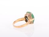 a close up of a gold ring with a green stone