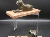 a pair of bronze statues of a dog and a cat on a wooden base