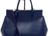 a close up of a blue handbag on a white background