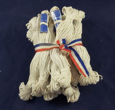 three white rope wrapped in blue and red ribbon on a blue background