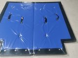 two pieces of blue plastic with black handles on a white floor