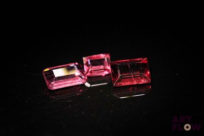 deux cubes roses de forme carrée posés sur une surface noire