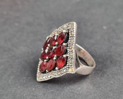 un gros plan d'une bague en argent sertie de pierres rouges