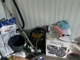 un tas d'objets par terre, à côté d'un aspirateur
