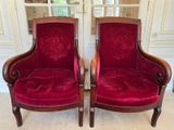 two red chairs sitting next to each other in a room