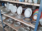 many plates and bowls on the shelves in the store