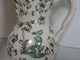 a white vase with a green and white design on it