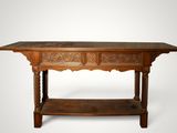 an old wooden table with two drawers and a shelf underneath it