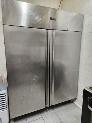 deux réfrigérateurs en acier inoxydable dans une cuisine, à côté d'une cuisinière