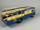 a blue and yellow double decker bus on a gray surface
