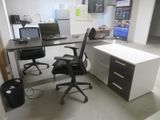 a desk with two computers and a chair in a room