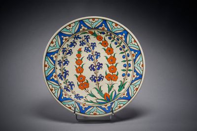 une assiette bleue et orange décorée de fleurs