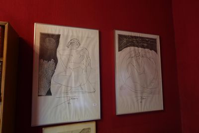 deux tableaux encadrés accrochés au mur d'une chambre rouge