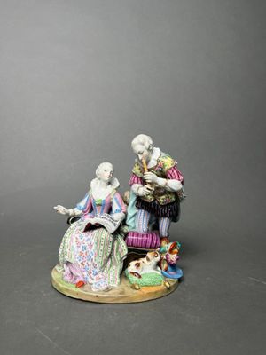 figurine of a man and woman sitting on a bench with a dog