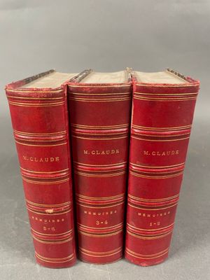 trois livres rouges superposés sur une table
