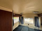 a view of the inside of a camper with blue carpeting