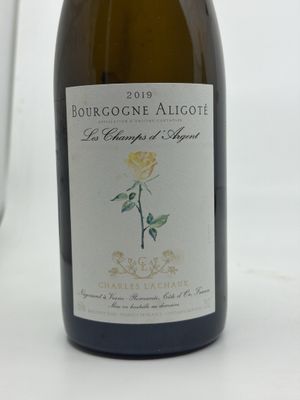 a bottle of wine sitting on a table next to a glass of wine