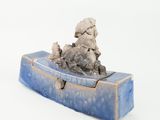 a small sculpture of a man on a boat on a white surface