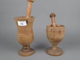 pair of wooden mortar and pest grinds on pedestals on grey background