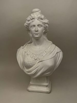 a white marble bust of a woman with curly hair