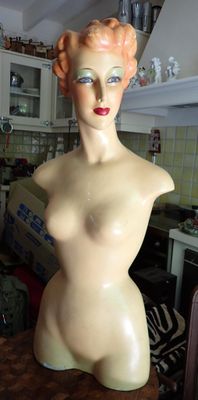un mannequin assis sur un plan de travail dans une cuisine
