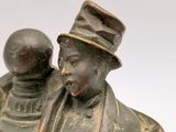 bronze statue of a man with a hat and a top hat