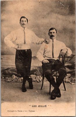 Sur une photo en noir et blanc, deux hommes posent pour une photo.