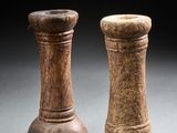 une paire de salières et poivrières en bois posées sur une surface grise