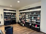 une photo d'un salon où les étagères regorgent de produits capillaires