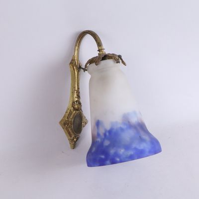 une applique murale dotée d'un abat-jour en verre bleu et blanc