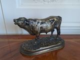 une statue représentant une vache debout sur une table en bois