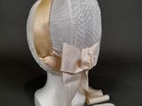 un chapeau blanc orné d'un ruban rose sur le dessus